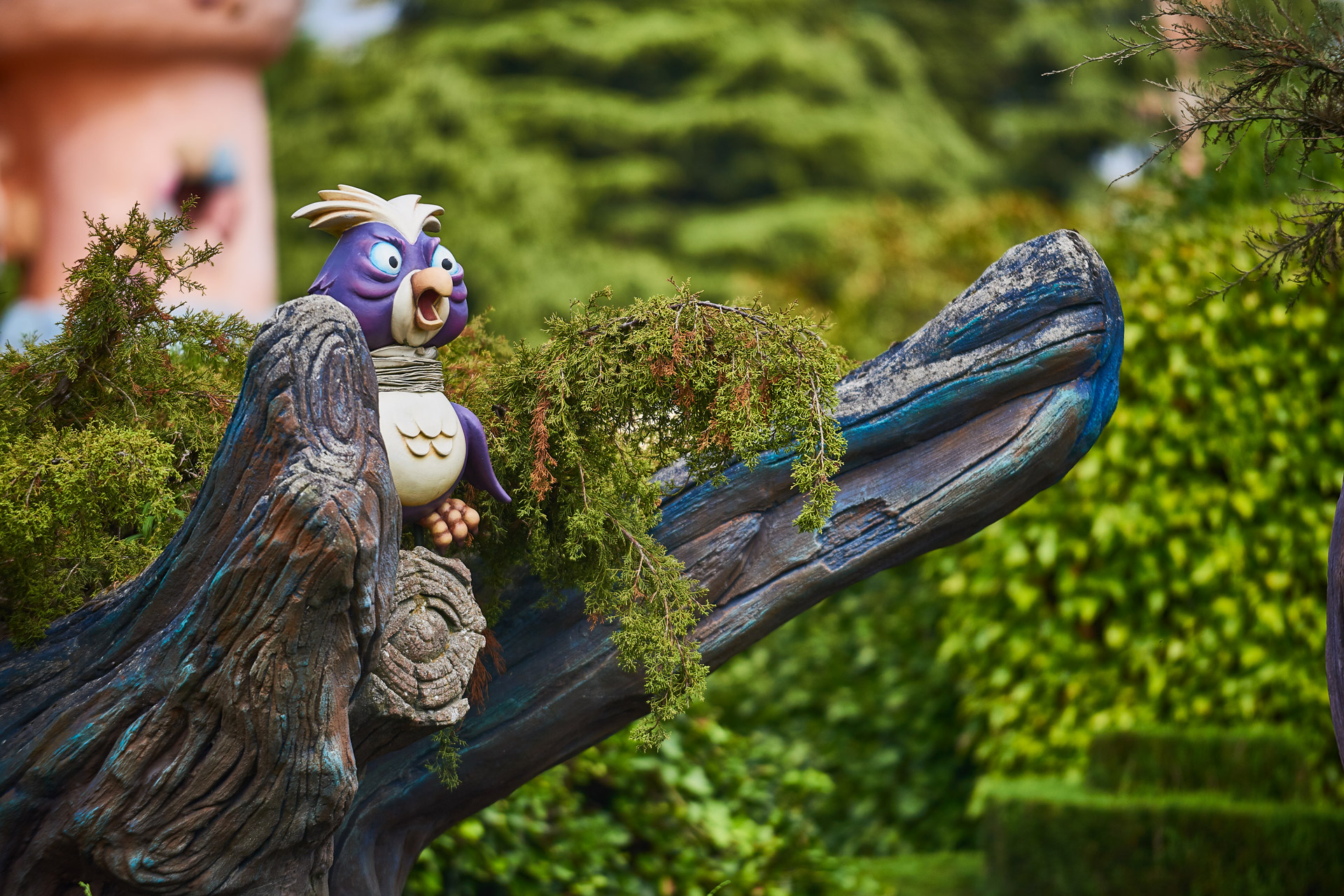 Un hibou tiré du dessin animé Alice au Pays des Merveilles se tient perché sur la branche d'un arbre.